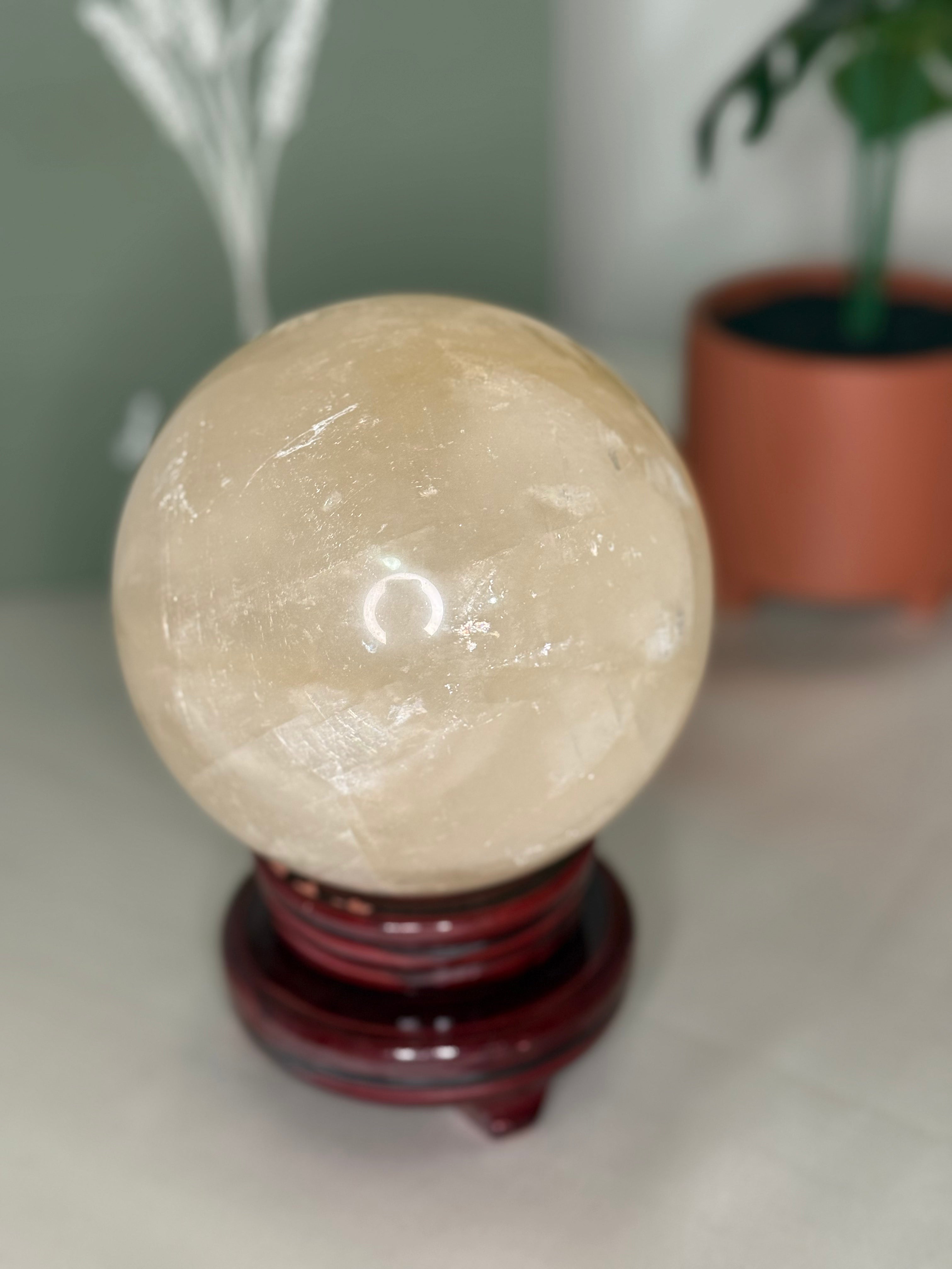 Large honey calcite sphere on spinning stand