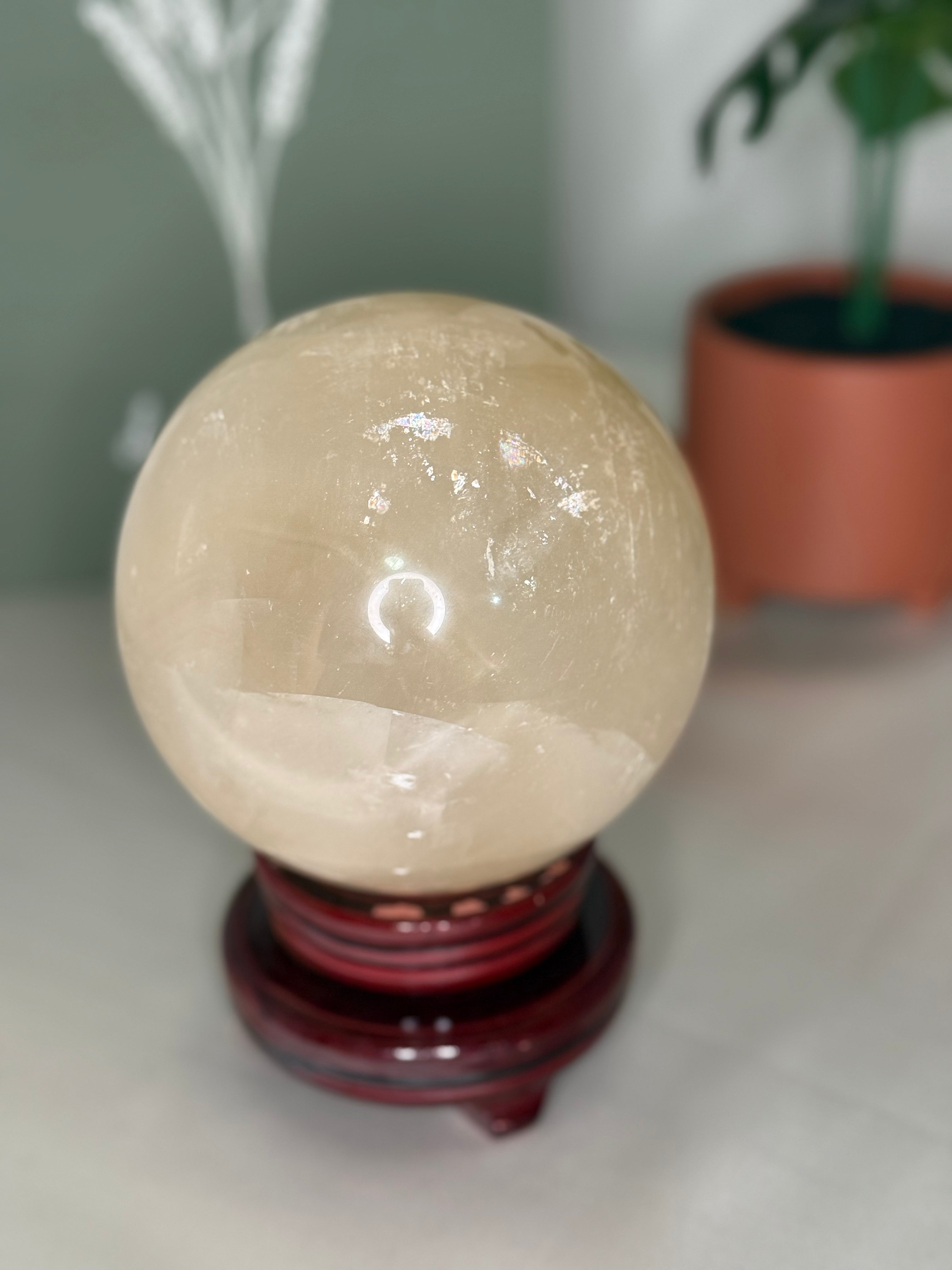 Large honey calcite sphere on spinning stand