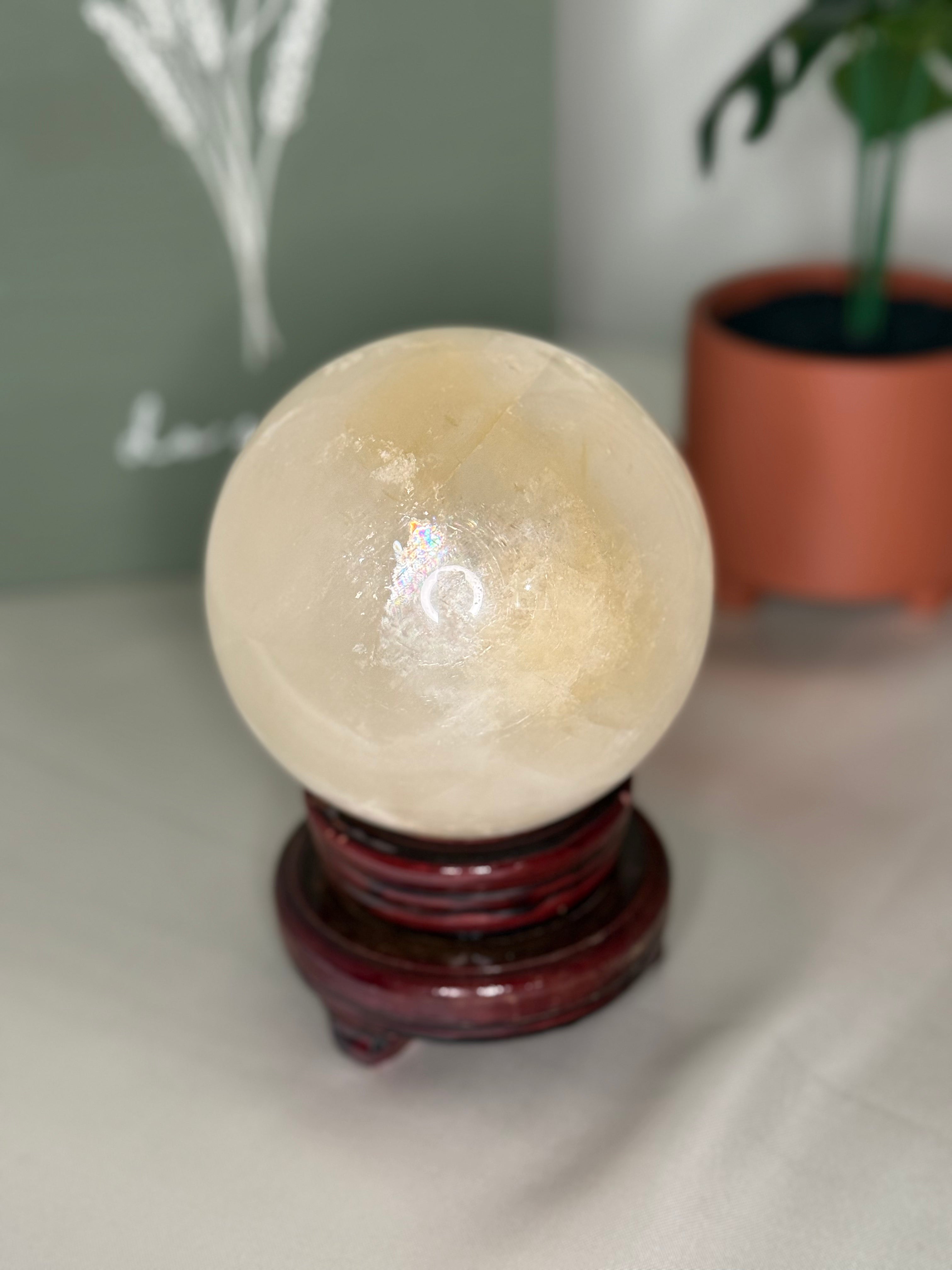 Honey calcite sphere on a spinning stand