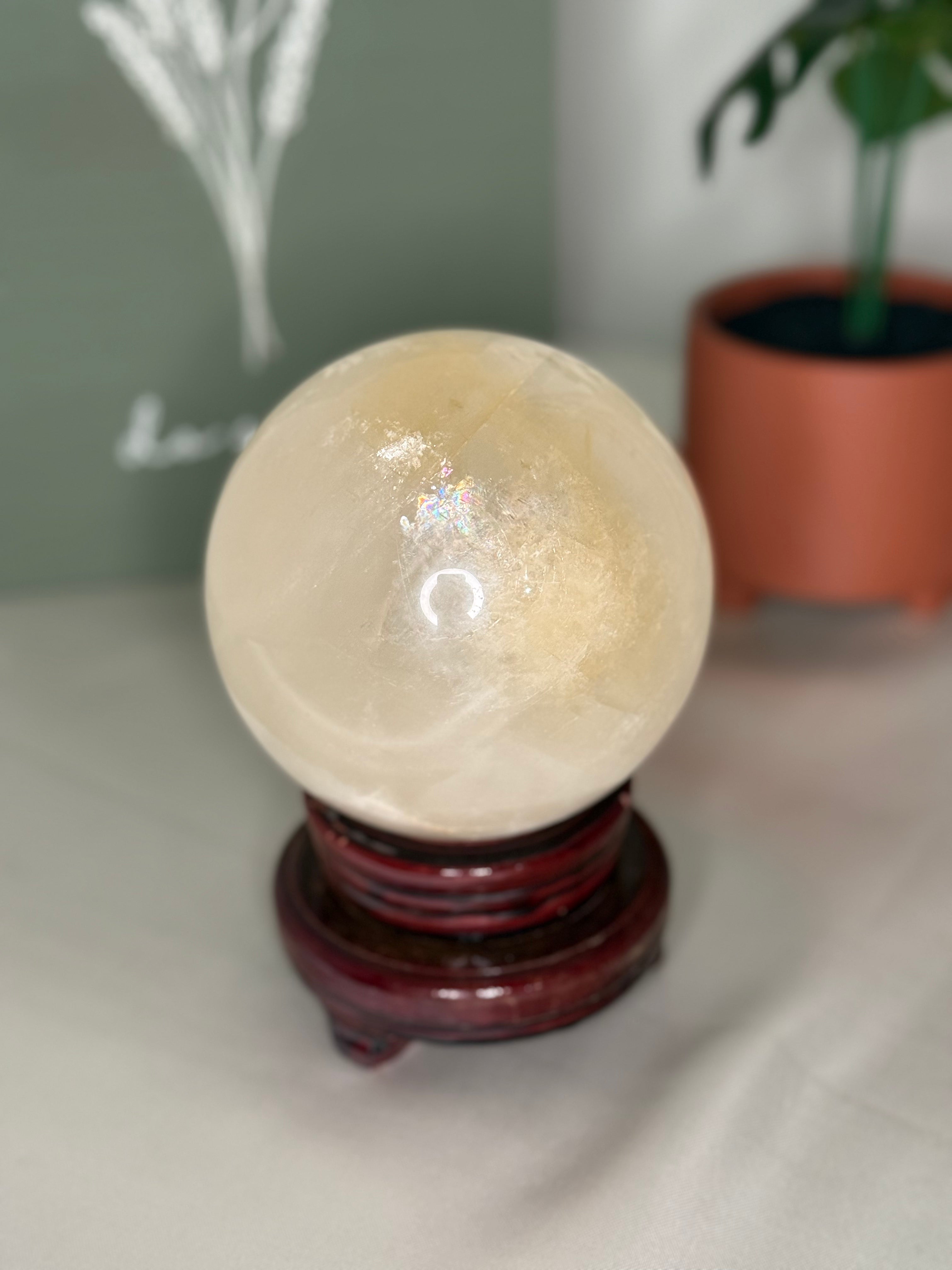 Honey calcite sphere on a spinning stand