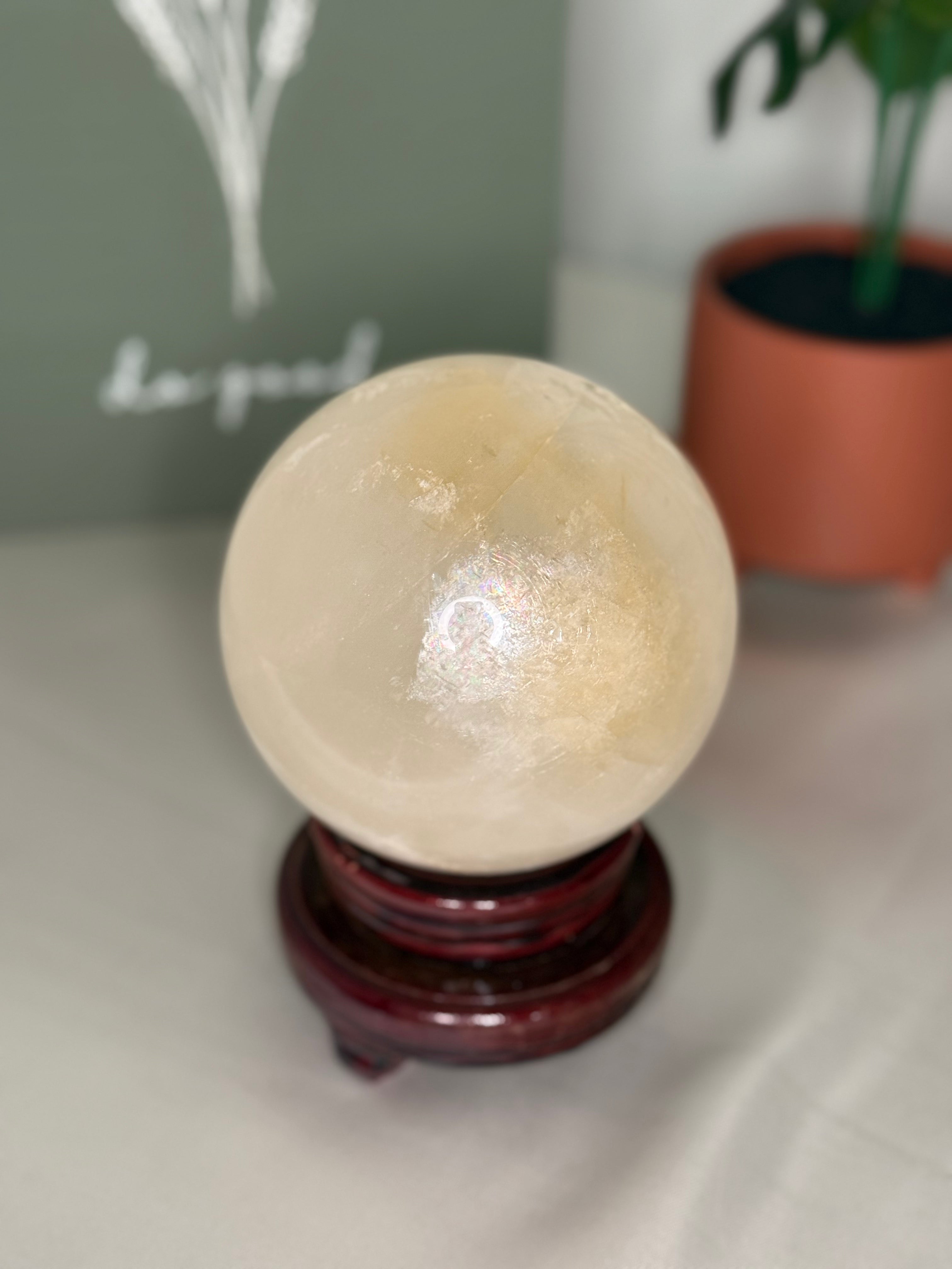 Honey calcite sphere on a spinning stand