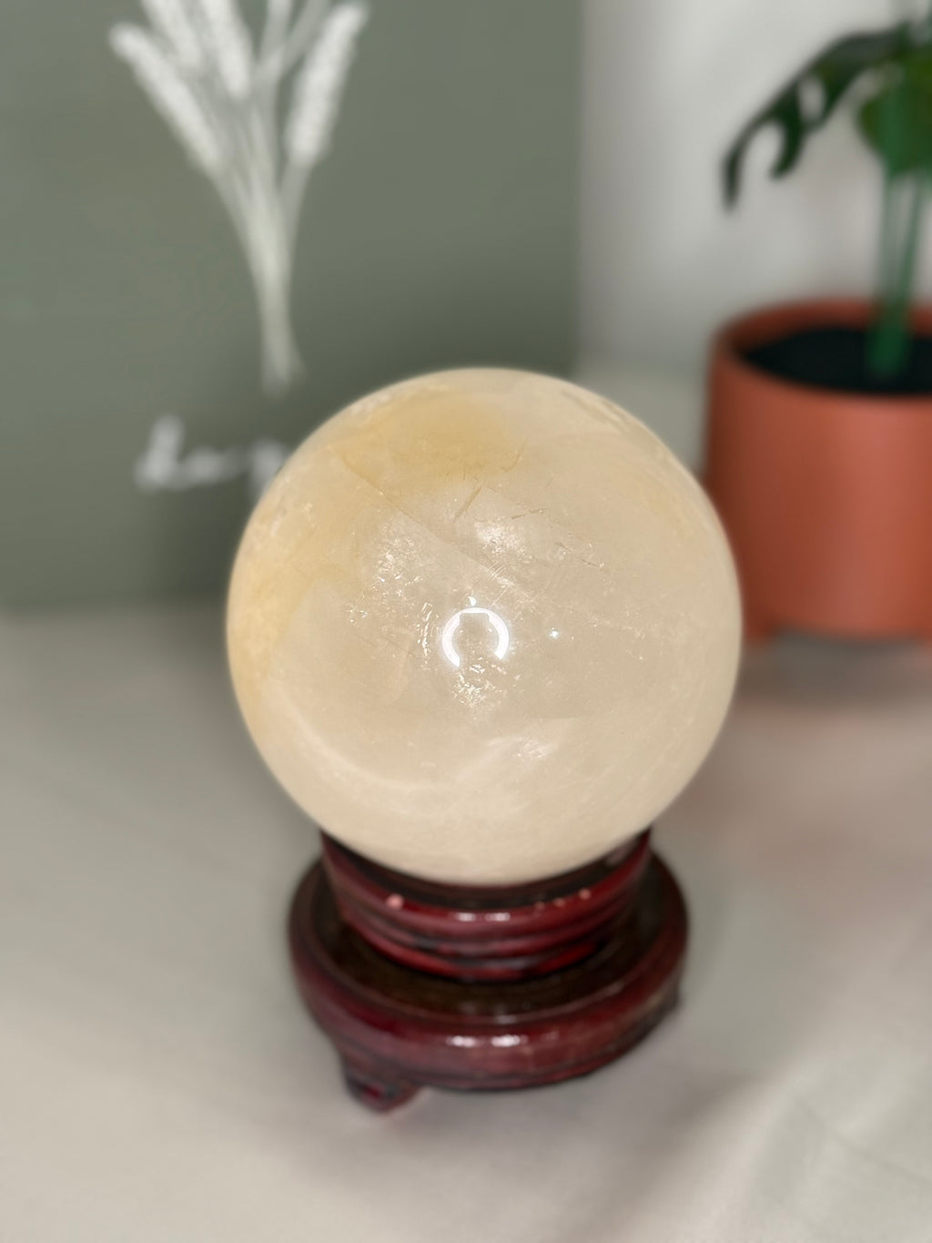 Honey calcite sphere on a spinning stand