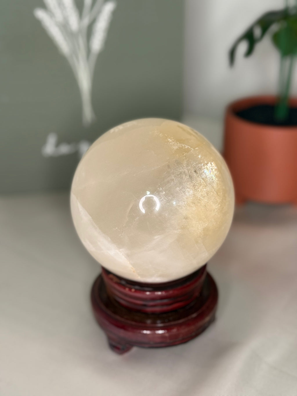 Honey calcite sphere on a spinning stand