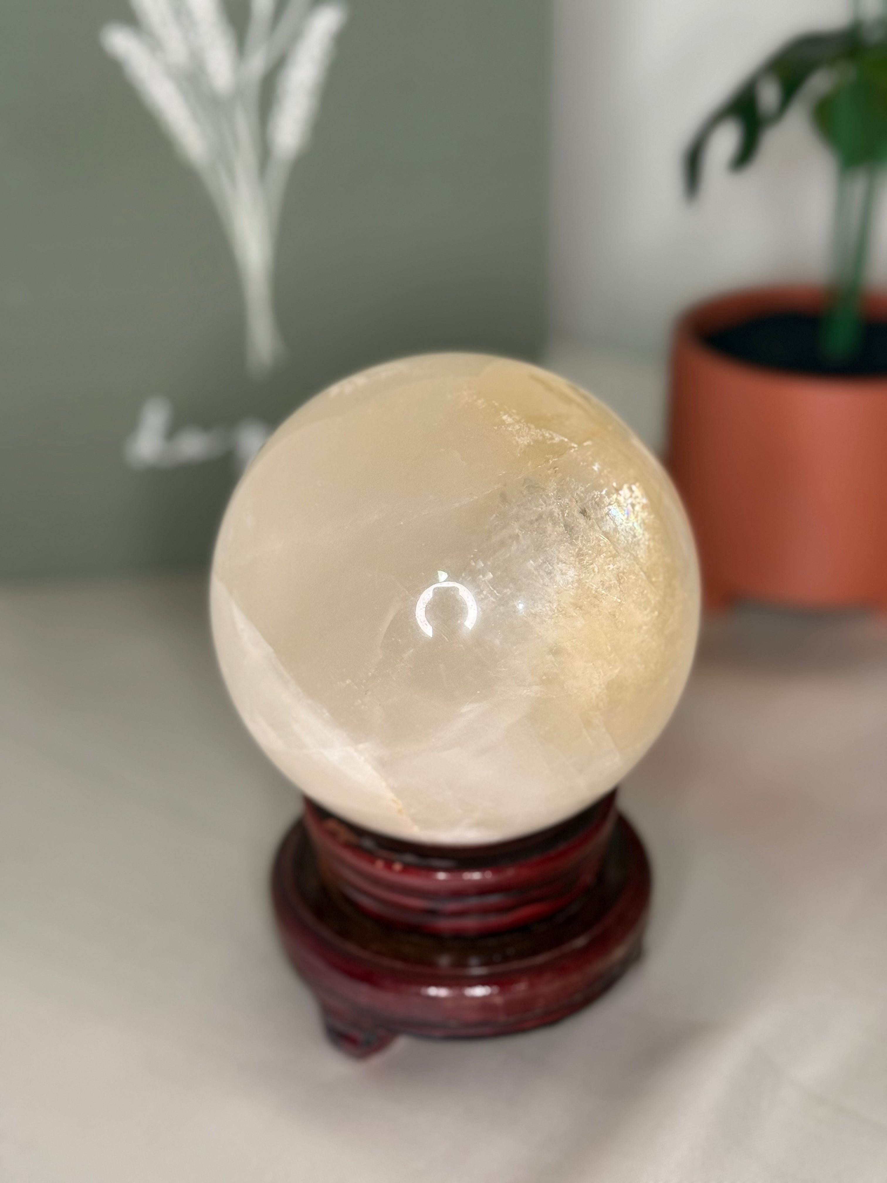Honey calcite sphere on a spinning stand