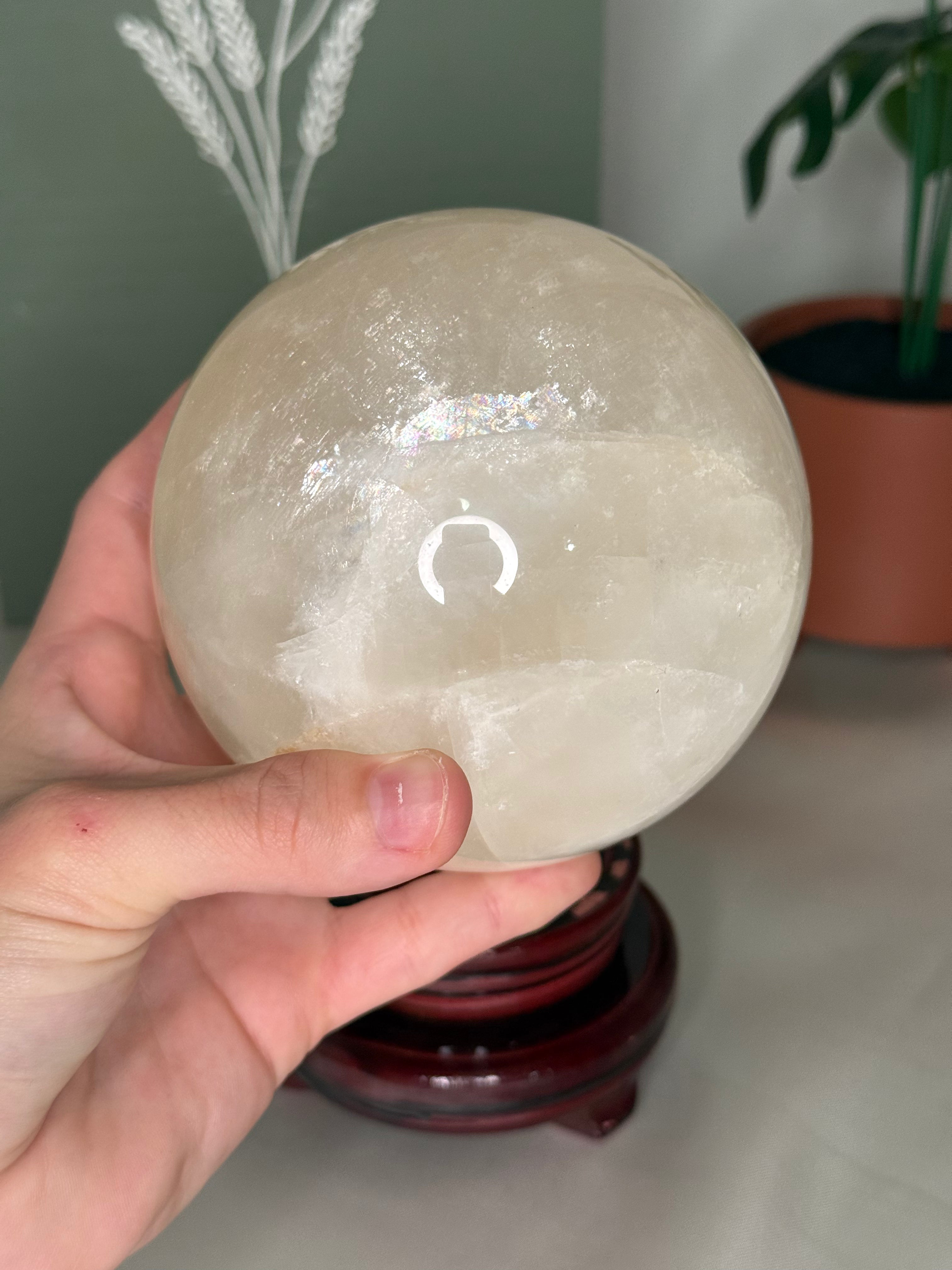 Honey calcite sphere on a spinning stand